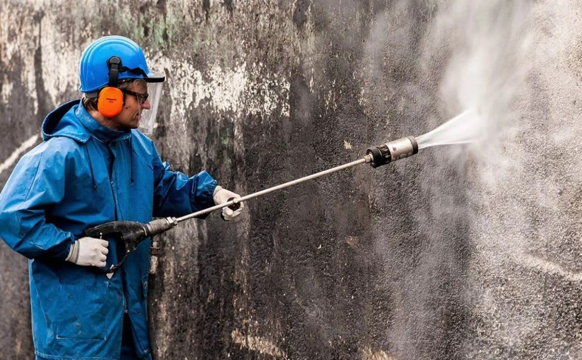 Operator conducting high pressure water blasting